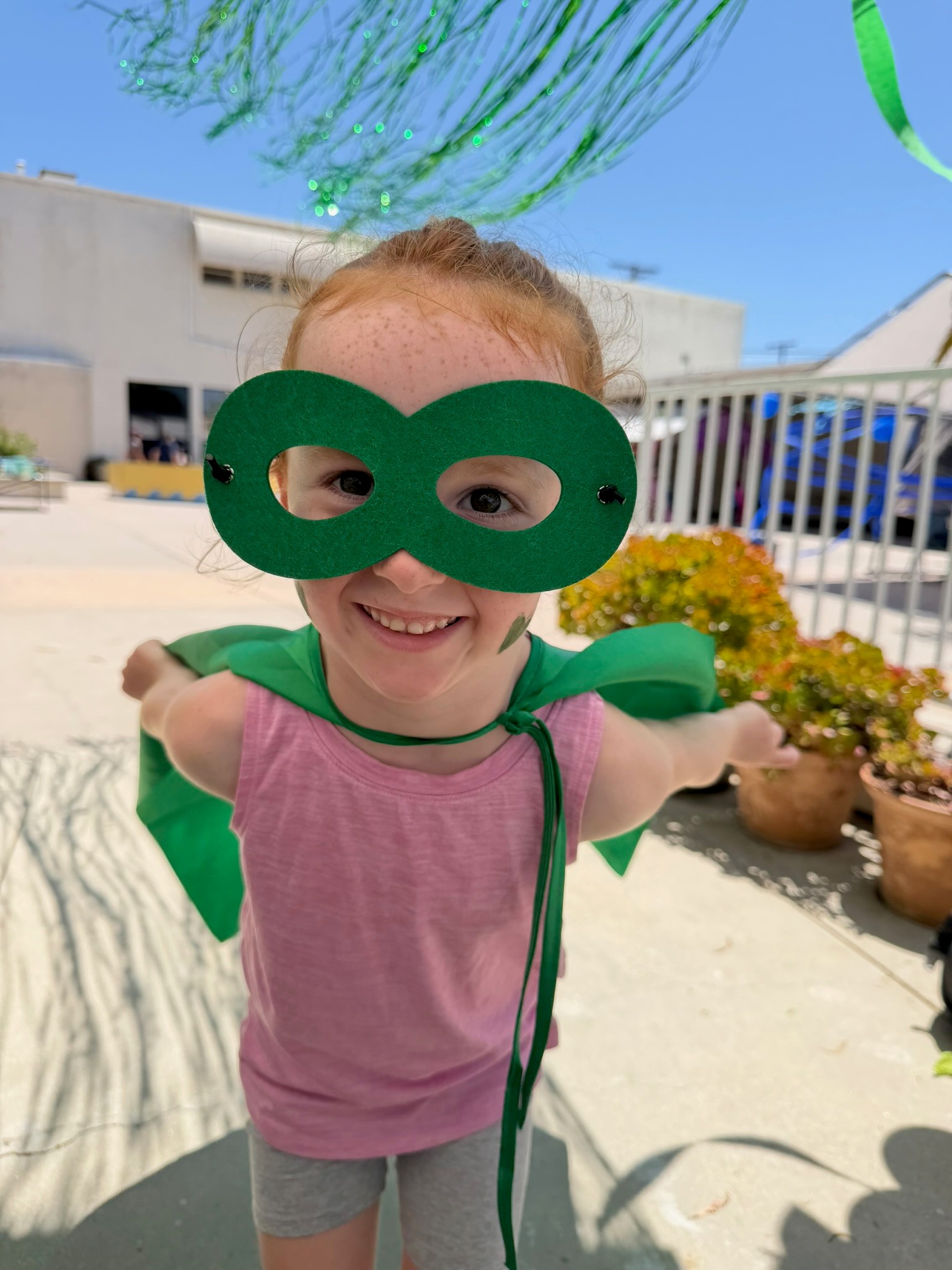 Smiling camper in a mask and cape